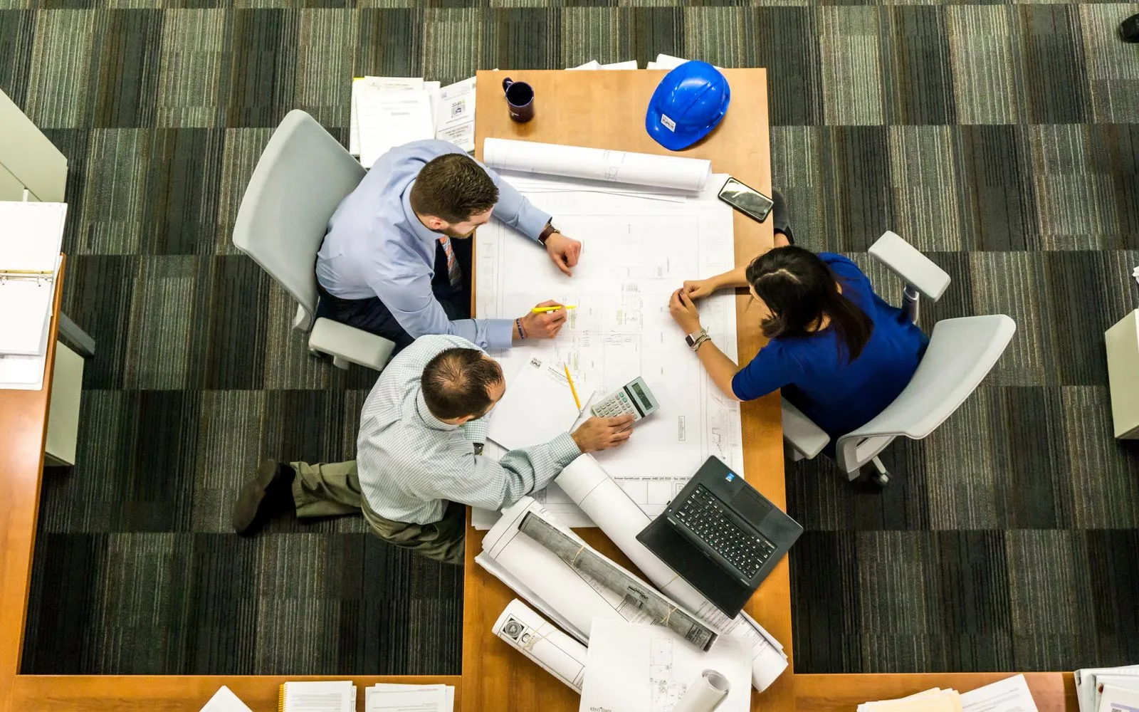 A project table with drawings, a calculator and a hard hat — a mining application is a Commission file, not a slogan