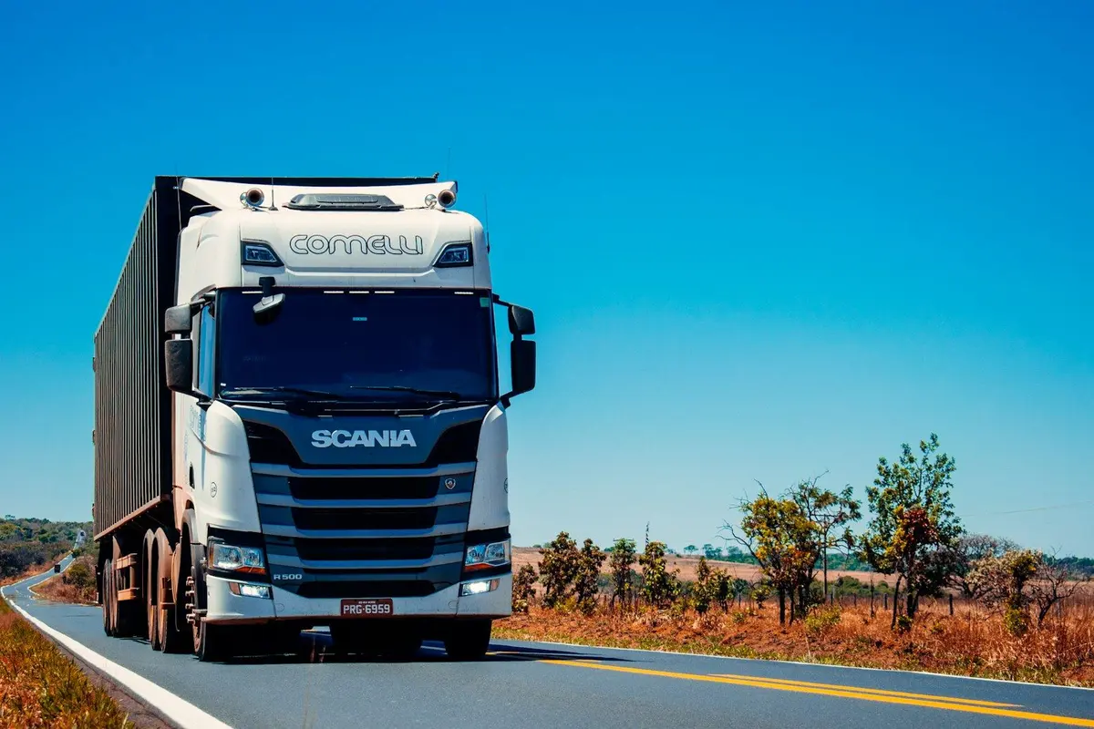 A supply truck on a bright road — mining local content is procurement, not a mineral right