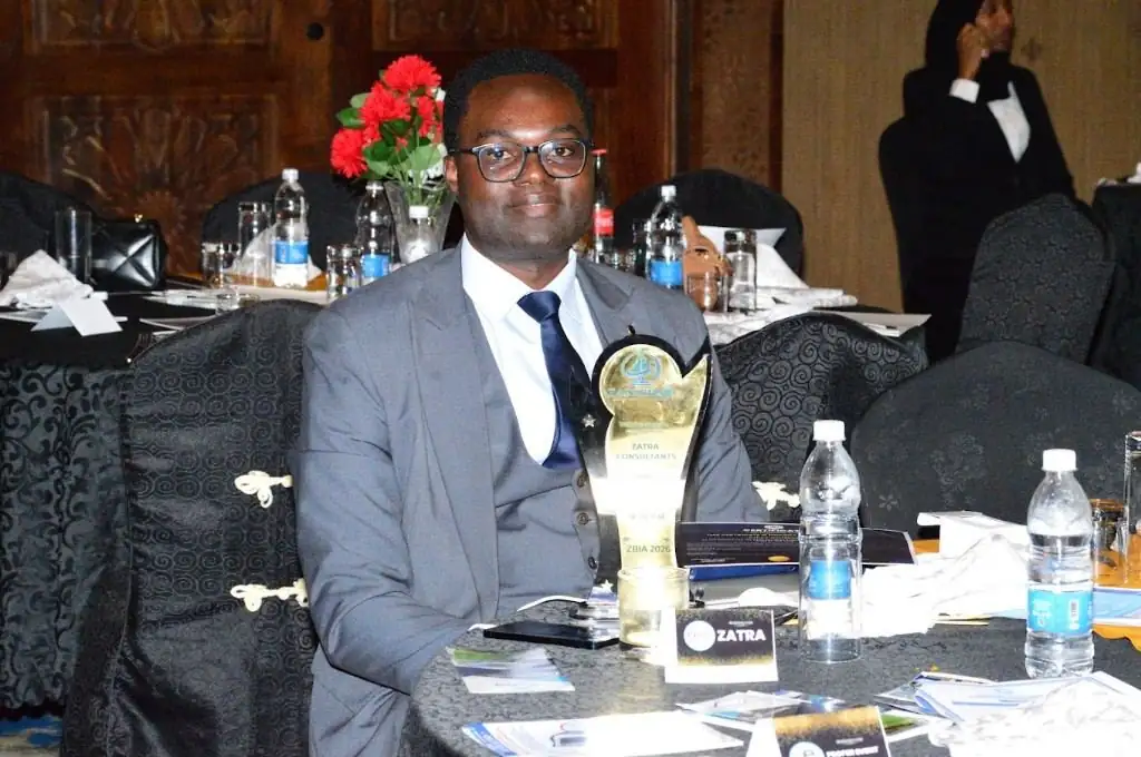 Zatra Consultants adviser with the firm's business consultancy award at the ceremony table.